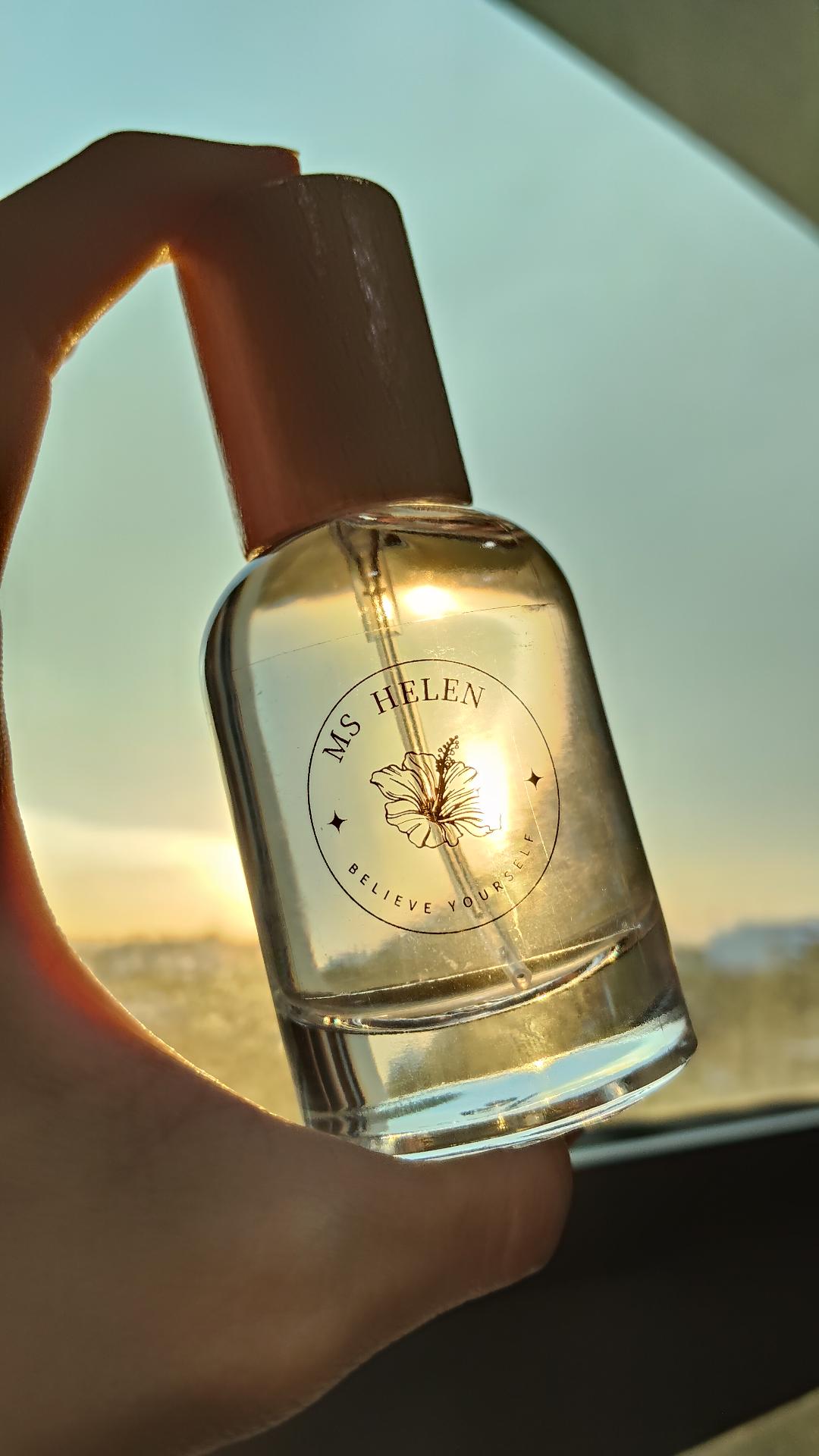 Be Yourself eau de parfum held against a sunset
